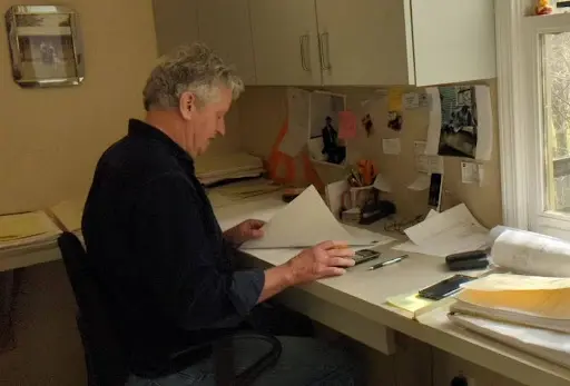 An experienced general contractor reviews plans at his desk